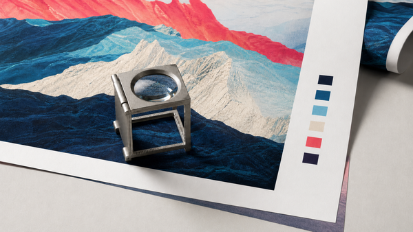 A foldable print loupe inspecting a large matte art proof beside unlabelled color-control patches