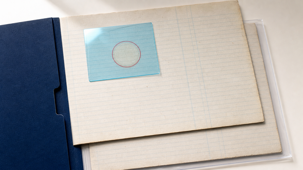 Blank ledger pages under cyan acetate review overlay