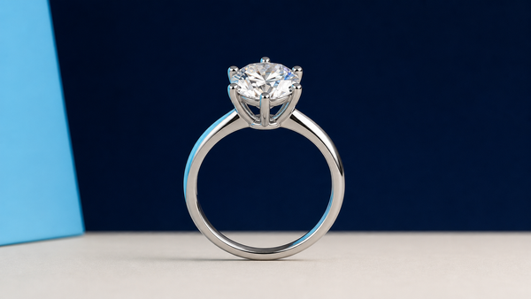 Silver solitaire ring with reflective metal on a navy studio background